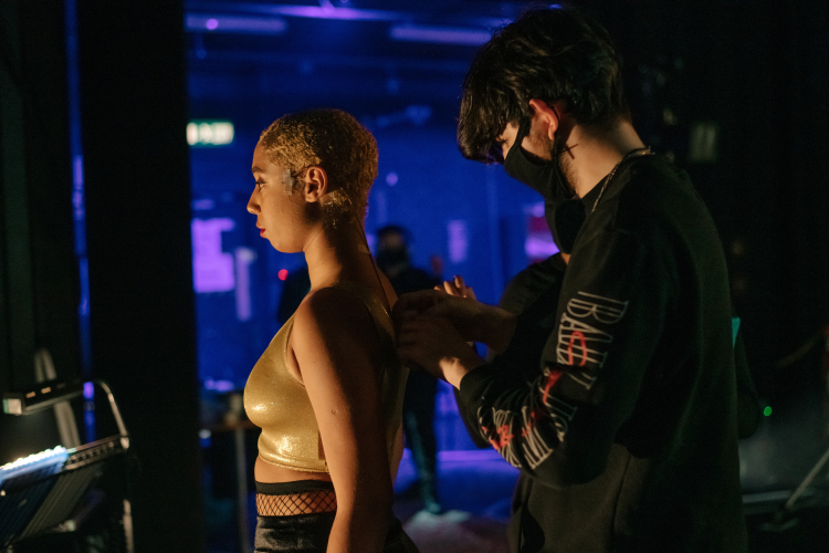 Sam Ferstenberg fixing a microphone on an actor